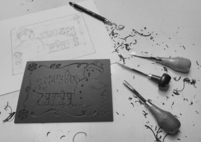 L'estampe des bonshommes de neige, linogravure en travail. Le dessin de base, la plaque de lino et les outils.
