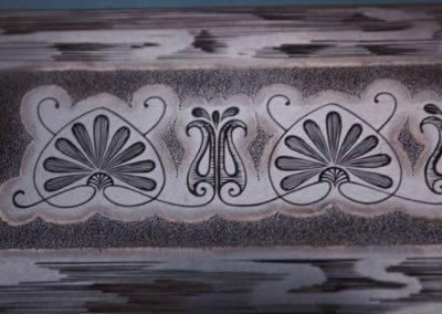 détail d'une bordure gravée de nénuphars stylisés. Plaque de "la demoiselle"