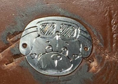 petit ours avec un casque et des lunettes gravé sur une plaquette de bracelet pour enfant.