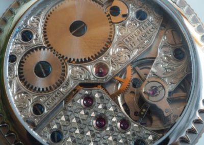 montre à mouvement apparent. Les 3 ponts du dessous sont entièrement gravés main. Un de mites géométriques, les deux autres de feuilles et de volutes.